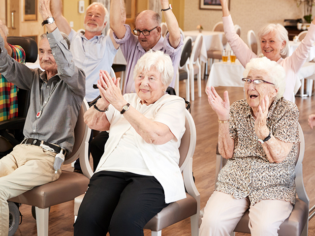 image of a group of seniors smiling together while in a retirement home