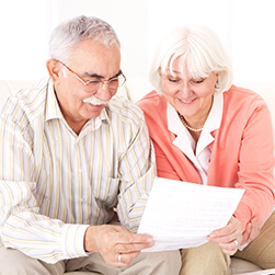 image of a senior couple reading at a piece a paper and smiling together